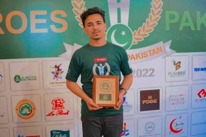 Syed Qadar Shah holding a Heroes of Pakistan appreciation token