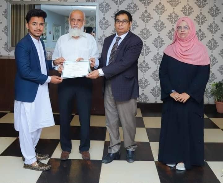 Syed Qadar Shah receiving an appreciation certificate after a session